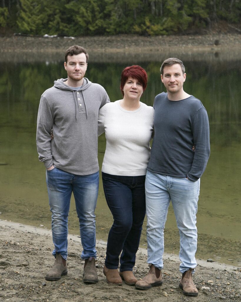 family posing in front of a lake